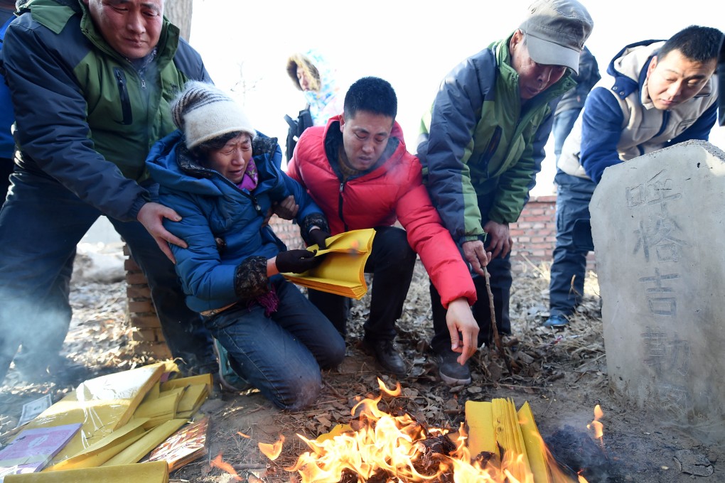 The parents of executed teenager Huugjilt mourn at this grave in Hohhot earlier this week after a court cleared him of rape and murder. Photo: Xinhua