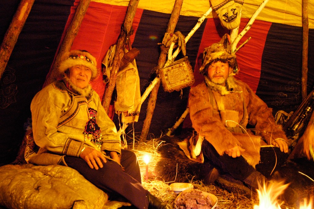 Oroqen hunter Ge Qingfu and his wife Meng Yufang sit in the seranju at night. Khingan National forest. Heilongjiang province, China.