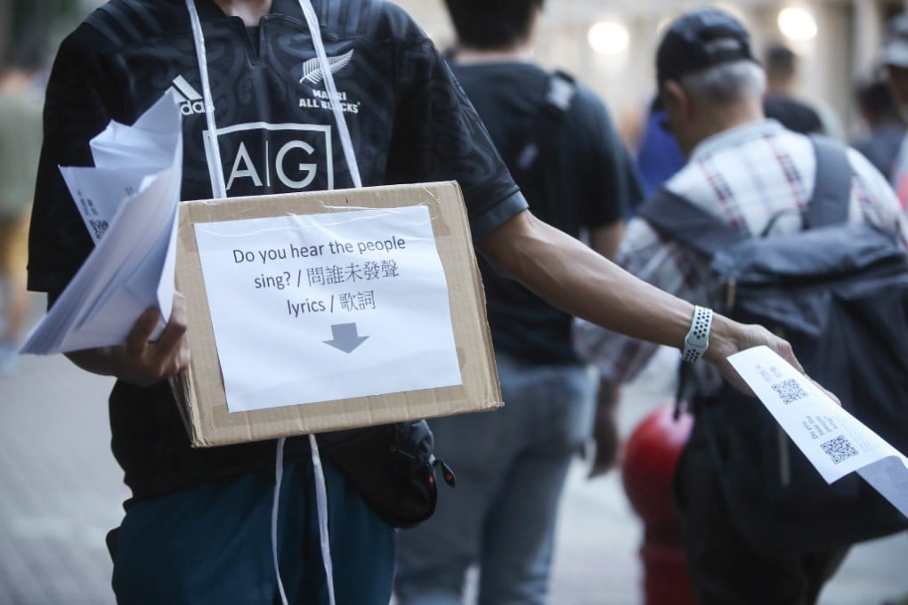 A fan hands out leaflets with lyrics for a planned demonstration at Hong Kong Stadium during the match between Manchester City and Kitchee. Photo:  K.Y. Cheng