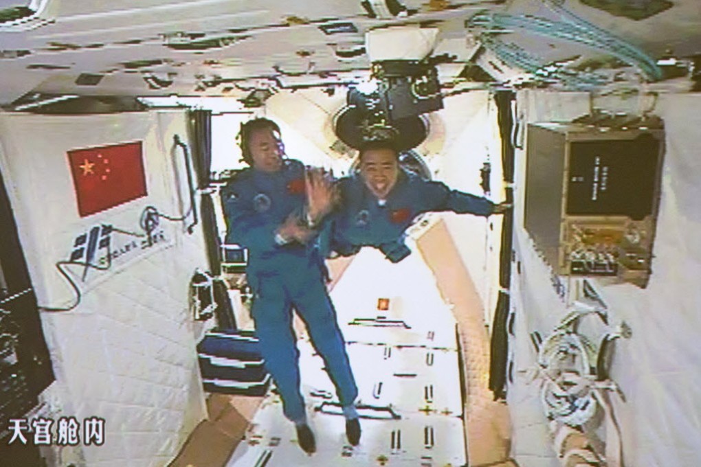 Chinese astronauts Jing Haipeng (left) and Chen Dong (right) entering the Tiangong-2 space lab on October 19, 2016. (Picture: Xinhua)