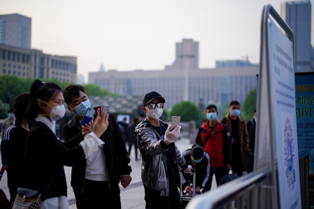 People in Wuhan scan a QR code at Wuhan's Hankou Railway Station to bring up their health codes on April 8 as travel restrictions for leaving the city are lifted. (Picture: Reuters)