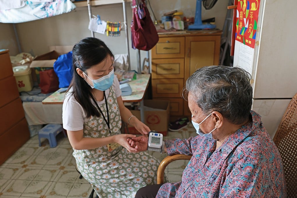 A nurse takes the temperature and blood pressure of an elderly woman.