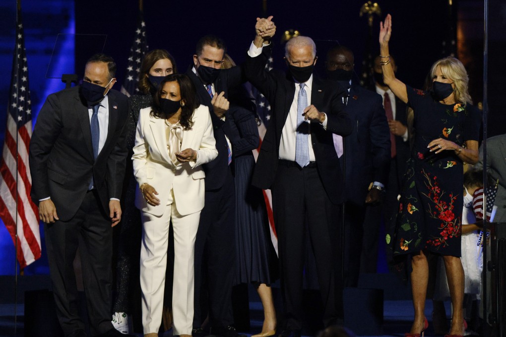 President-elect Joe Biden holds up his son Hunter's hand, as they and vice president-elect Kamala Harris and their families celebrate onstage in Wilmington, Delaware. Photo: Reuters