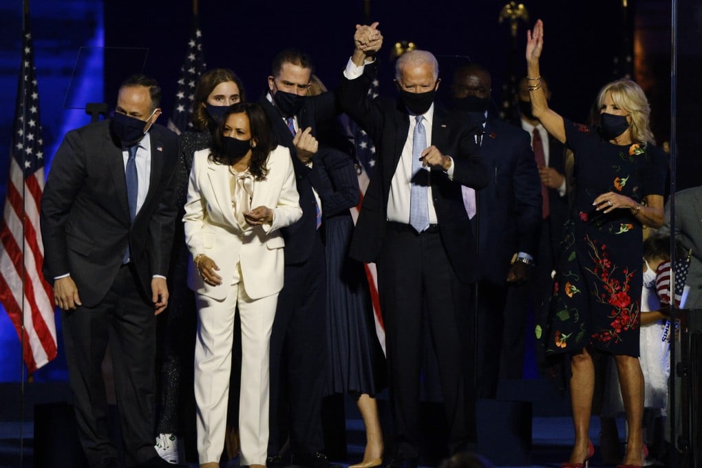 President-elect Joe Biden holds up his son Hunter's hand, as they and vice president-elect Kamala Harris and their families celebrate onstage in Wilmington, Delaware. Photo: Reuters