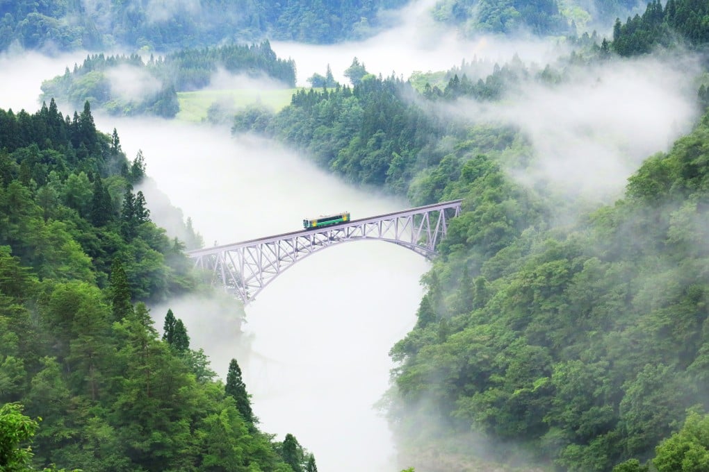 A train on the Tadami Line crosses the No 1 Tadami River Bridge between Aizu Hinohara and Aizu Nishikata in Japan. Photo: Ken Hoshi