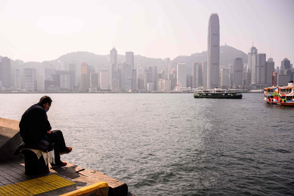 A man sits by the Victoria Harbour in Hong Kong on January 27. The travel restrictions and social distancing measures have had an impact on the economy but they are necessary for now. Photo: AFP