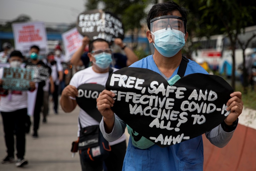 A health worker holds a placard calling for free, safe, and effective Covid-19 vaccines during a protest in Manila, Philippines. Photo: Reuters