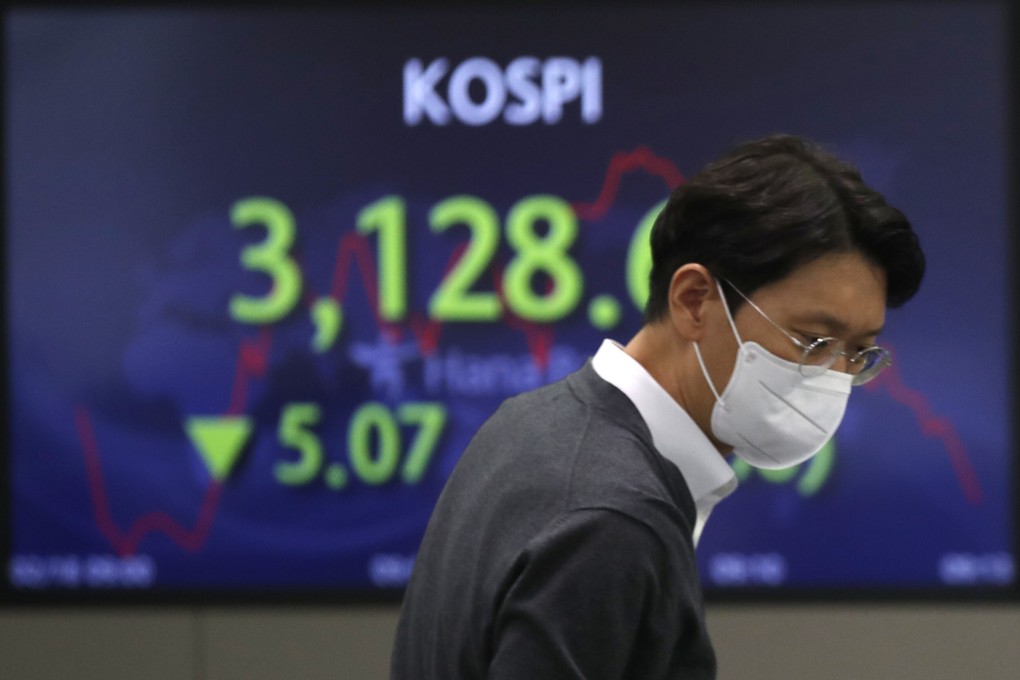 A currency trader walks near a screen showing the Korea Composite Stock Price Index at a foreign exchange dealing room in Seoul on February 18. Photo: AP