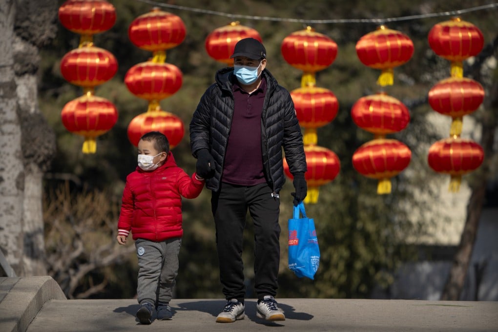 A man and child wear masks in a public park in Beijing. China has not lifted its birth rate more than four years after ending the one-child policy. Photo: AP
