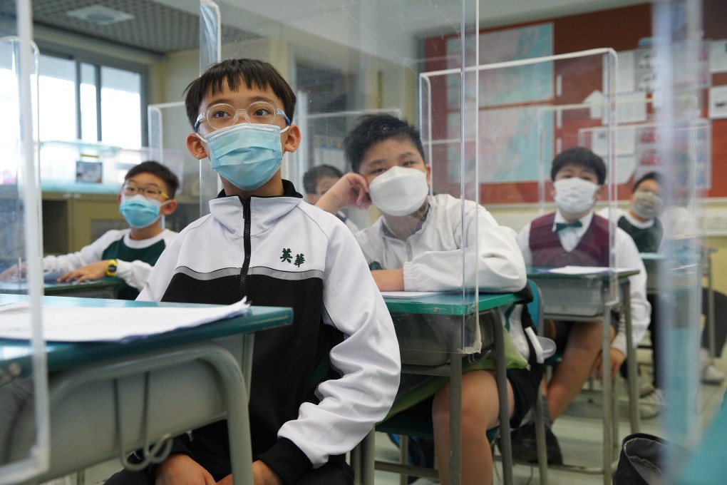 Dividers are set up on each student’s desk to maintain social distancing as some classes resume at a school in in Cheung Sha Wan on February 21. Photo: Winson Wong