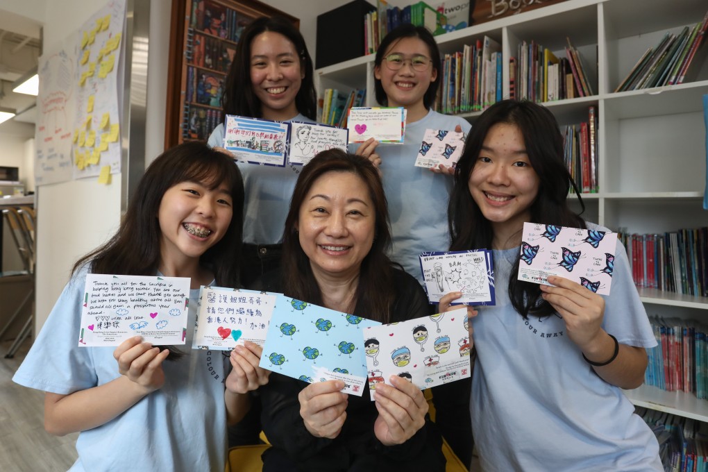 Members of the Colour Away Covid project (clockwise, from top left) Yuka Suzuki, Hui Yu-hang, Shawn Chan, Kids4Kids executive director Mabel Sieh, and Tsang Yau-yau, with postcards containing encouraging messages for frontline health care workers at the Kids4Kids offices in Wan Chai, Hong Kong. Photo: Jonathan Wong