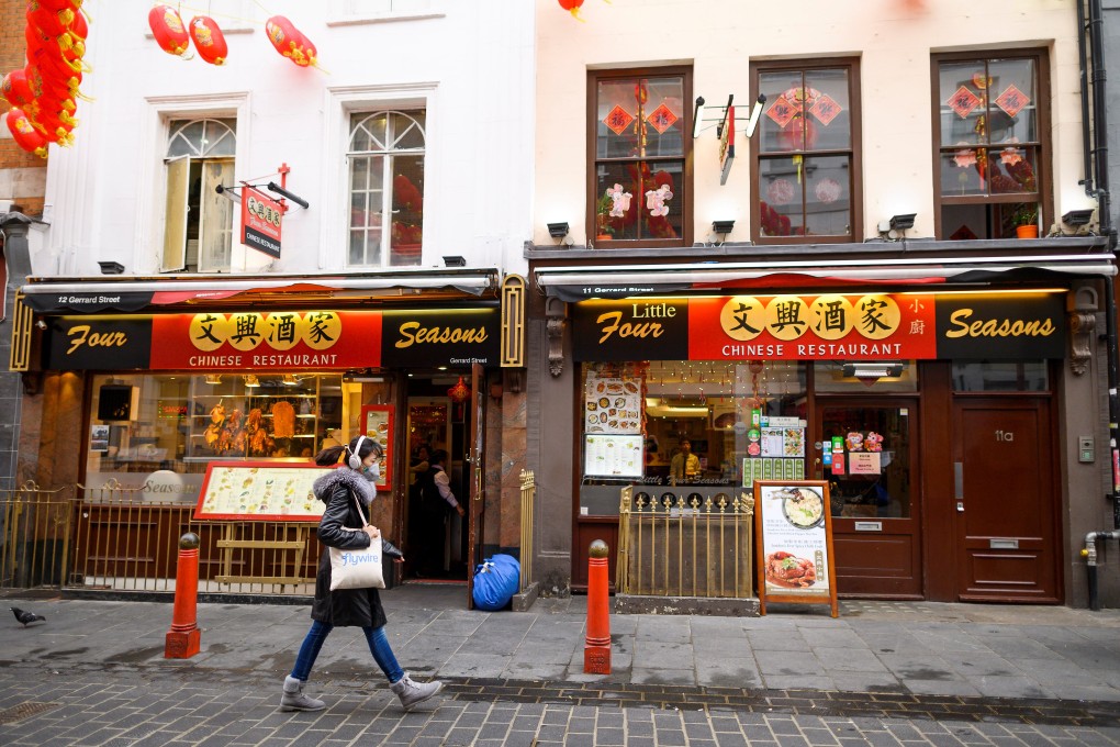 A woman walks past a restaurant in London’s China Town district on February 4, 2020. As Covid-19 spread, Asian communities around the world have found themselves subject to suspicion and fear. Photo: AFP