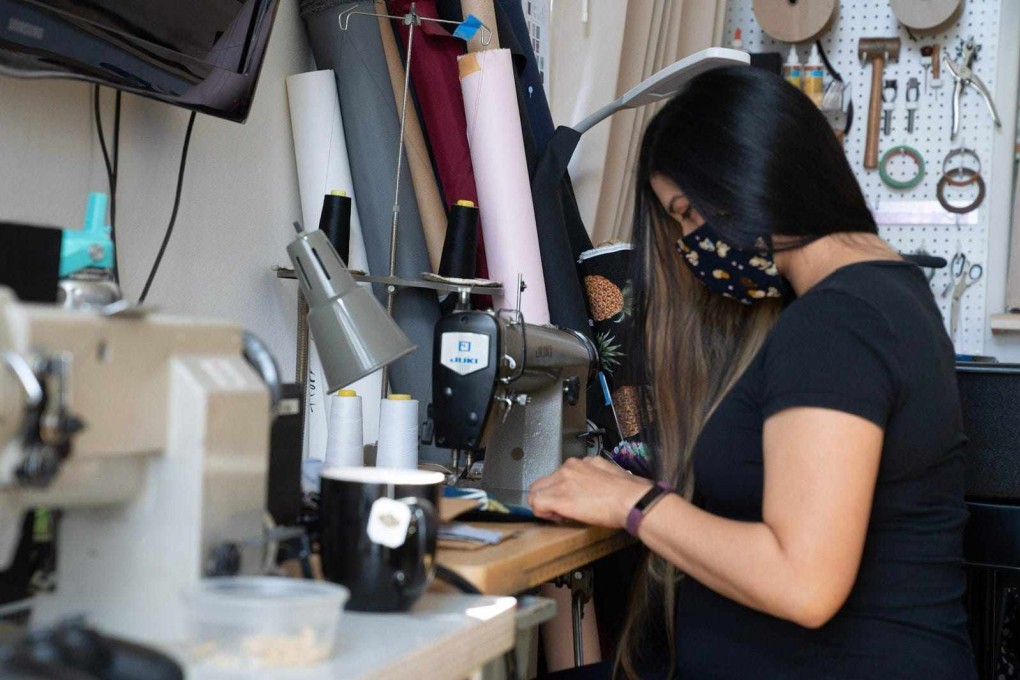 Small Asian clothing companies turned to making fabric masks with their unused inventory during the pandemic. Nikki Manahan sews masks at her sewing machine. Photo: courtesy of Manahan