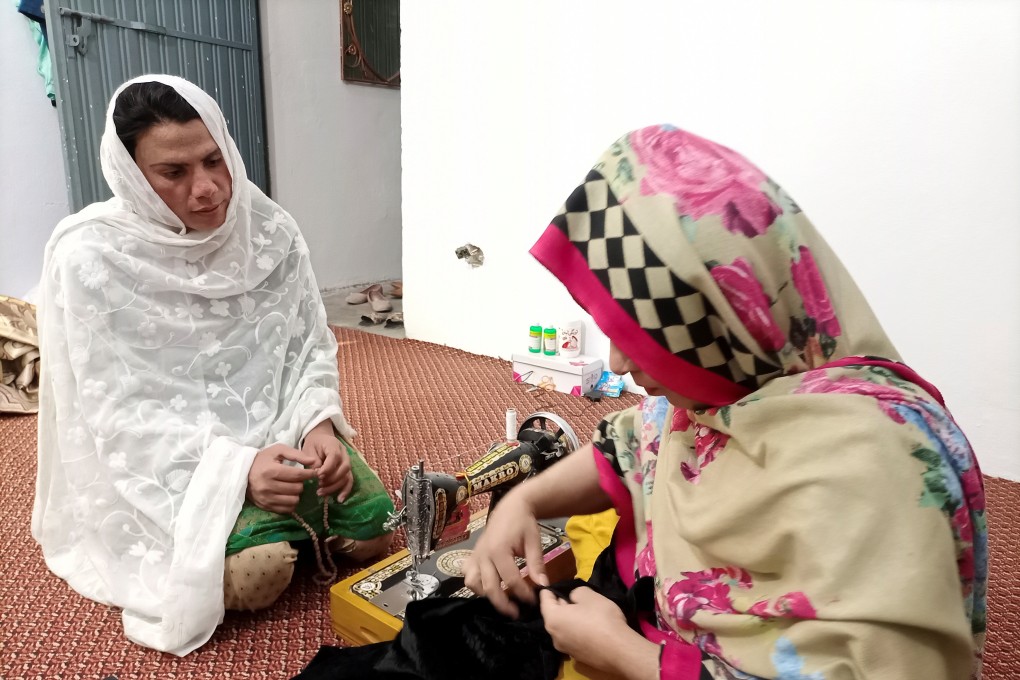 Rani Khan, a transgender woman who teaches the Koran at Pakistan’s first transgender-only madrasa, helps a student during a lesson on tailoring. Photo: Reuters