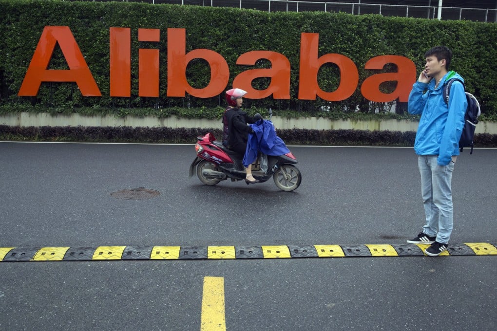 A woman rides past Alibaba’s headquarters in Hangzhou, Zhejiang province. Photo: AP Photo