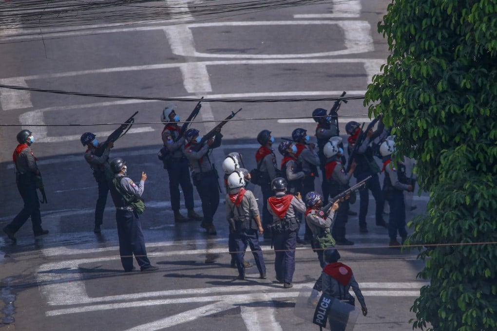 Myanmar security forces aim guns towards people in nearby apartments as they stand-off with anti-coup protesters in Yangon earlier this month. Photo: AP