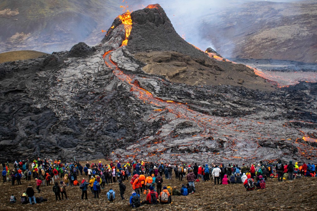 Sunday hikers look at the lava flowing from the erupting Fagradalsfjall volcano, 40 km west of the Icelandic capital, Reykjavik. Photo: Jeremie Richard/AFP