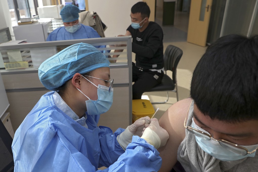 Airport workers are inoculated in Nantong in China’s eastern Jiangsu province. Sinopharm conducted a Covid-19 vaccine delivery dry run in December last year to ensure its cold-chain logistics system was safe and efficient. Photo: AP