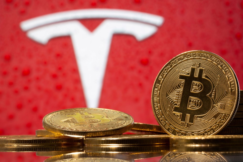 Representations of virtual currency bitcoin are seen in front of the Tesla logo. Photo: Reuters
