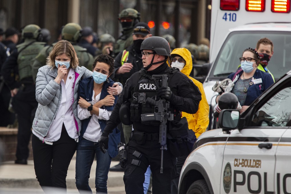 Health care workers walk out of a King Soopers Grocery store after a gunman opened fire on Monday. Photo: Getty Images/TNS
