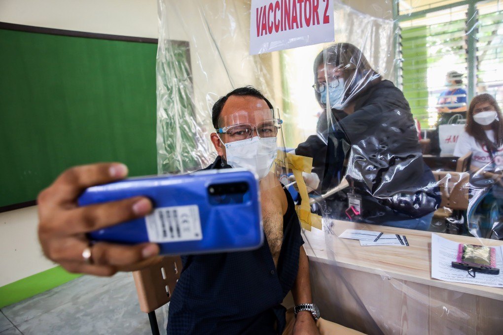 A health worker takes a selfie as he receives a dose of the AstraZeneca Covid-19 vaccine in Manila. Photo: Xinhua