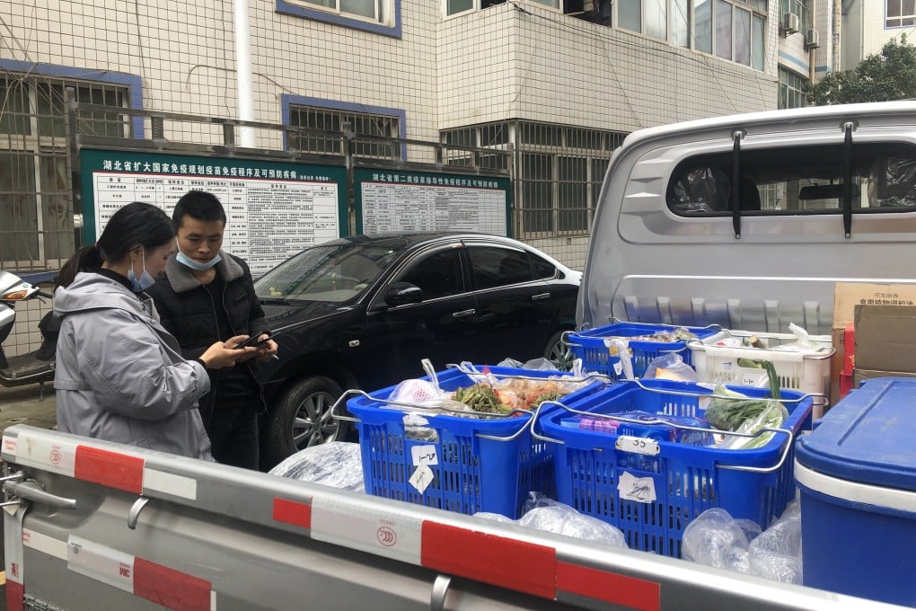 Xiang Meiling, a community leader for group-buying platform Meituan Youxuan, checks groceries purchased by members in her community in Lichuan county, Hubei province, China. Photo: Jane Zhang
