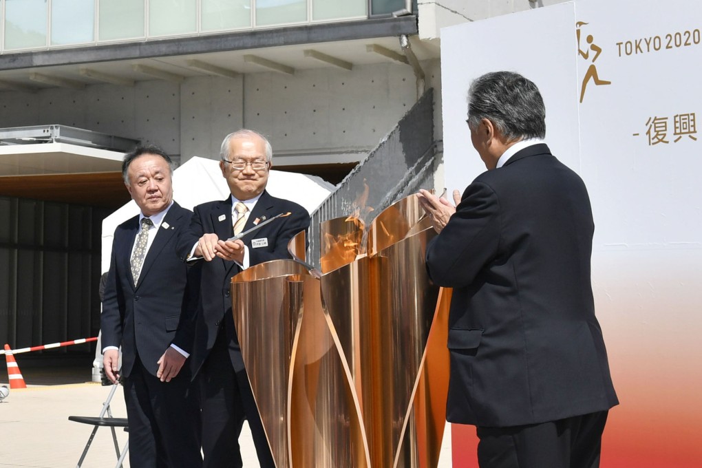 A ceremony is held for the transferring of the Olympic flame as the torch relay gets underway. Photo: Kyodo