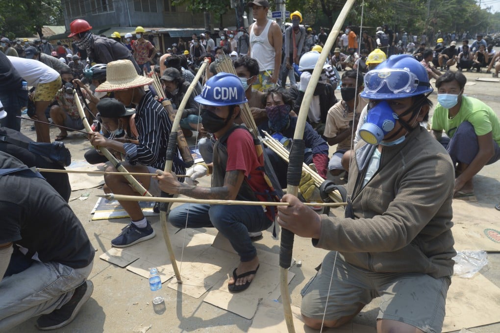 Anti-coup protesters prepare makeshift bow and arrows to confront police in Thaketa township, Yangon. Photo: AP