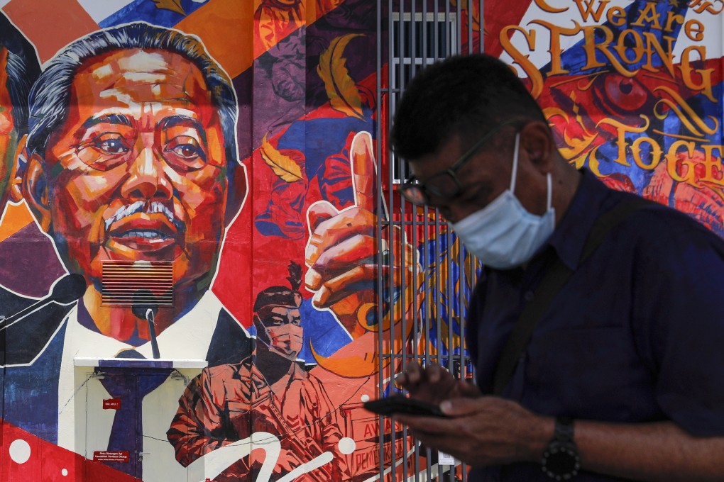 A man passes by a mural depicting Malaysia’s Prime Minister Muhyiddin Yassin in Kuala Lumpur. Photo: EPA