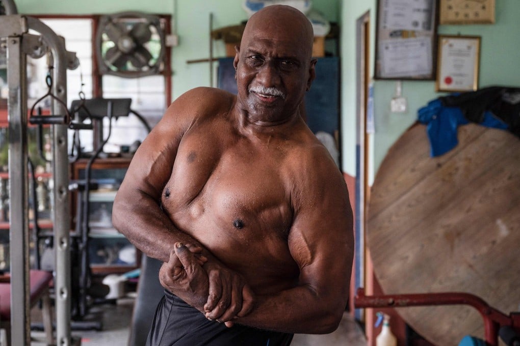Malaysian bodybuilder A. Arokiasamy flexes his muscles after training at his gym in Teluk Intan, Perak, Malaysia. He still pumps iron every day, and believes staying healthy through a vigorous fitness routine is the best defence against coronavirus. Photo: AFP
