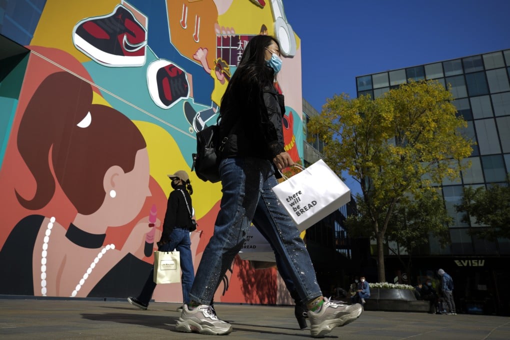 Women walk past a popular shopping mall in Beijing, on October 19, 2020. China’s economic recovery from the coronavirus pandemic is gaining strength as consumers return to shopping malls and auto dealerships. Photo: AP