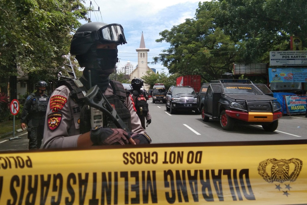 Armed police officers stand guard along a closed road following an explosion outside a Catholic church in Makassar, South Sulawesi province, Indonesia on Sunday. Photo: Antara Foto / Arnas Padda via Reuters