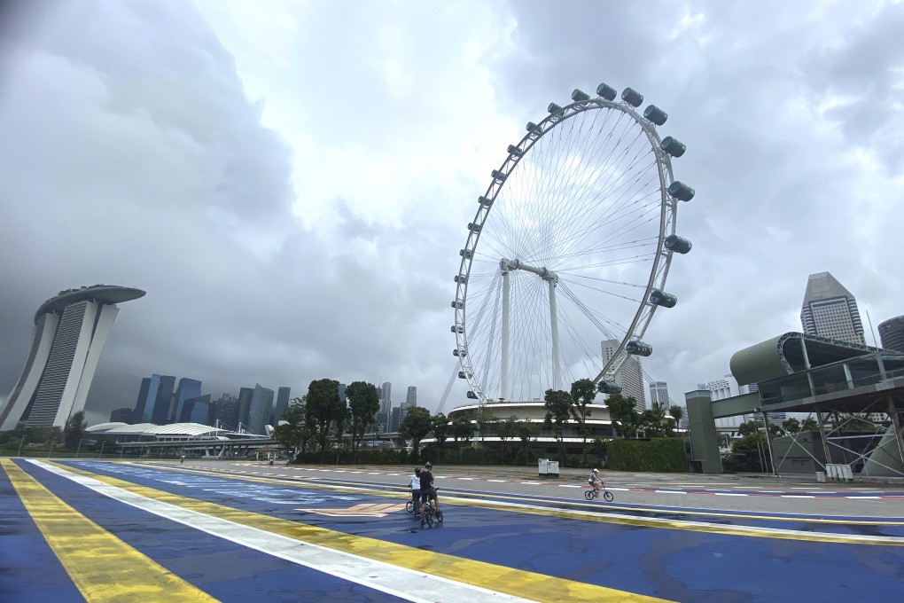 Cyclists pass the Singapore Flyer Ferris Wheel. Photo: AP