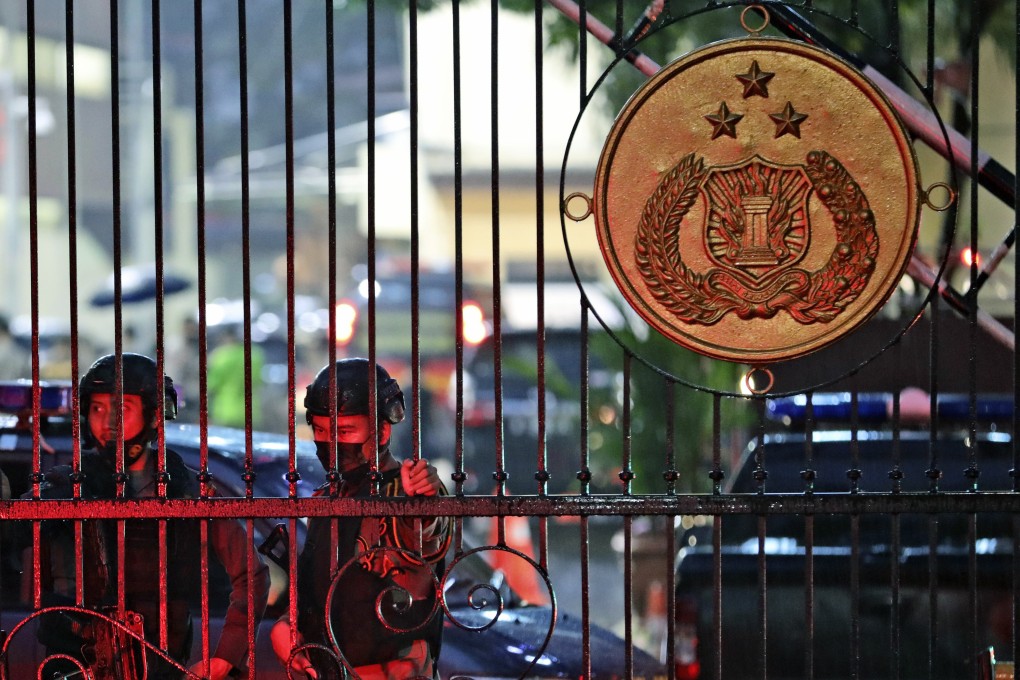 Police officers stand guard at the main gate of the National Police Headquarters in Jakarta following a suspected militant attack. Photo: AP