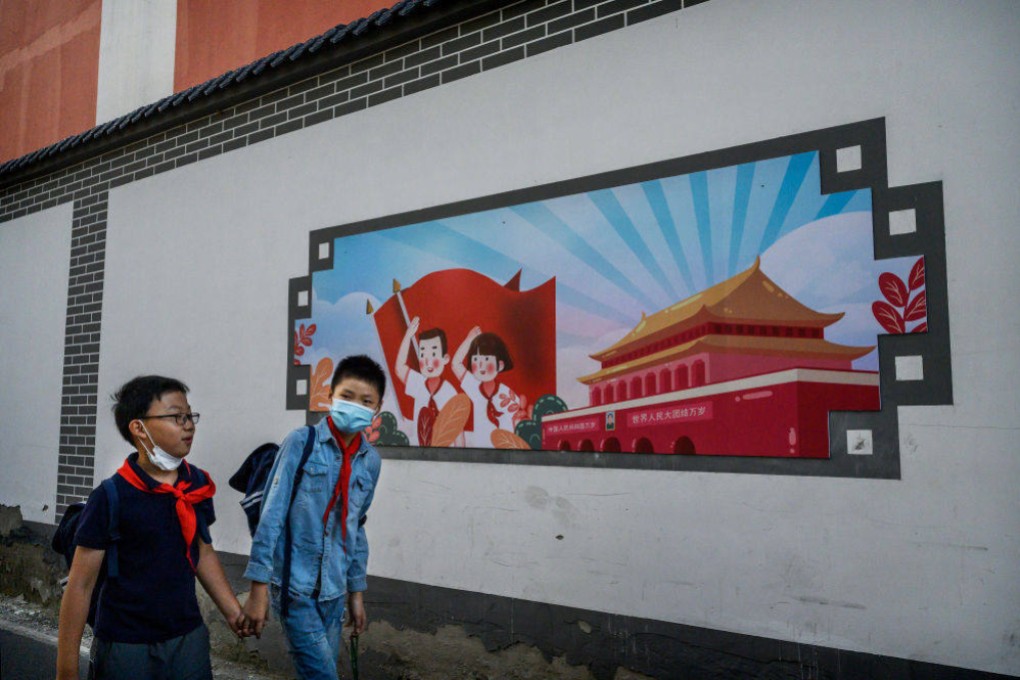 Chinese boys pass a patriotic banner as they walk home together after school on September 17, 2020, in Beijing. For a hybrid foreign-Chinese education model to work, it must be based on China’s excellent traditional culture. Photo: Getty Images