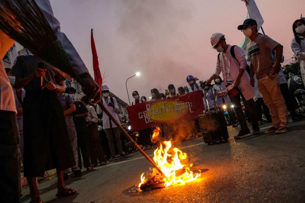 Protesters burning copies of the 2008 constitution during a demonstration against the military coup in Mandalay. Photo: AFP