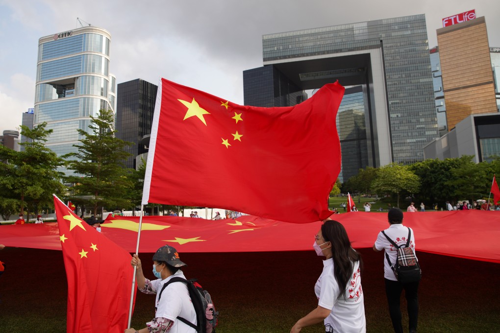 Residents carry the national flag outside Hong Kong’s government complex on Tuesday to show their support of a radical revamp of the city’s electoral system. Photo: Winson Wong