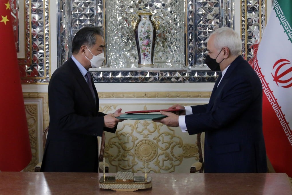 Chinese Foreign Minister Wang Yi and his Iranian counterpart Mohammad Javad Zarif exchange documents during a signing ceremony in Tehran on Saturday. Photo: EPA-EFE
