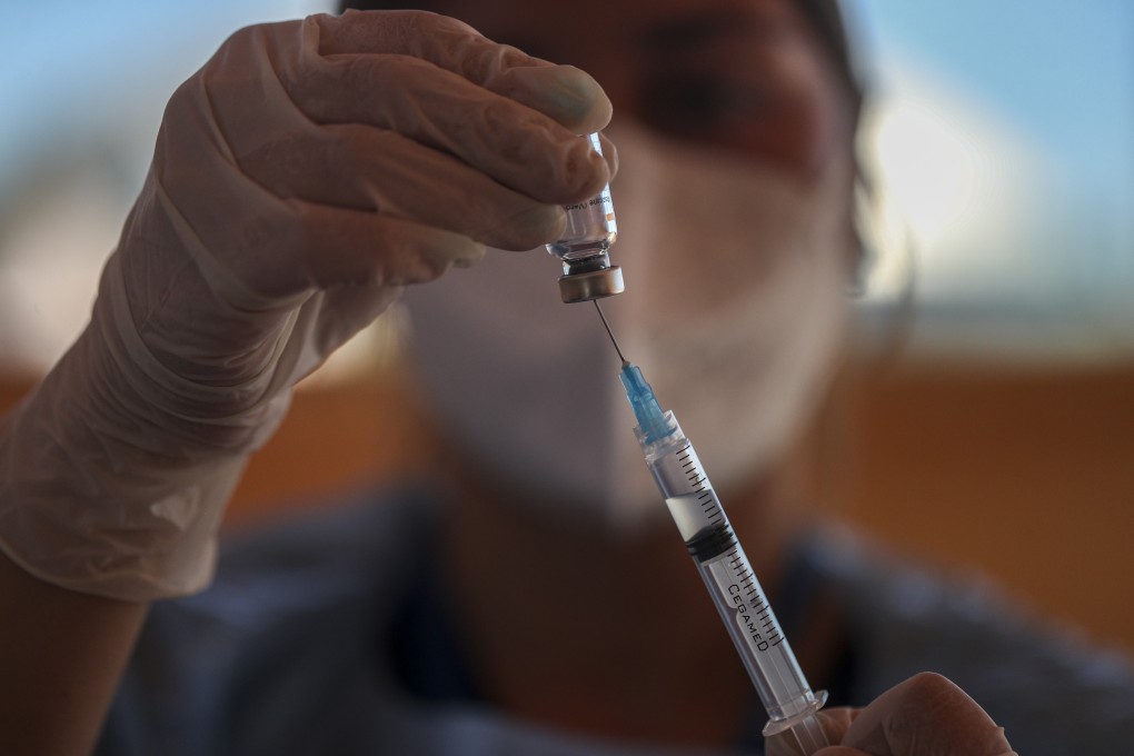 A health worker prepares a dose of the Sinovac Covid-19 vaccine at a drive-thru vaccination site during a citywide lockdown in Santiago, Chile, in March. Photo: AP