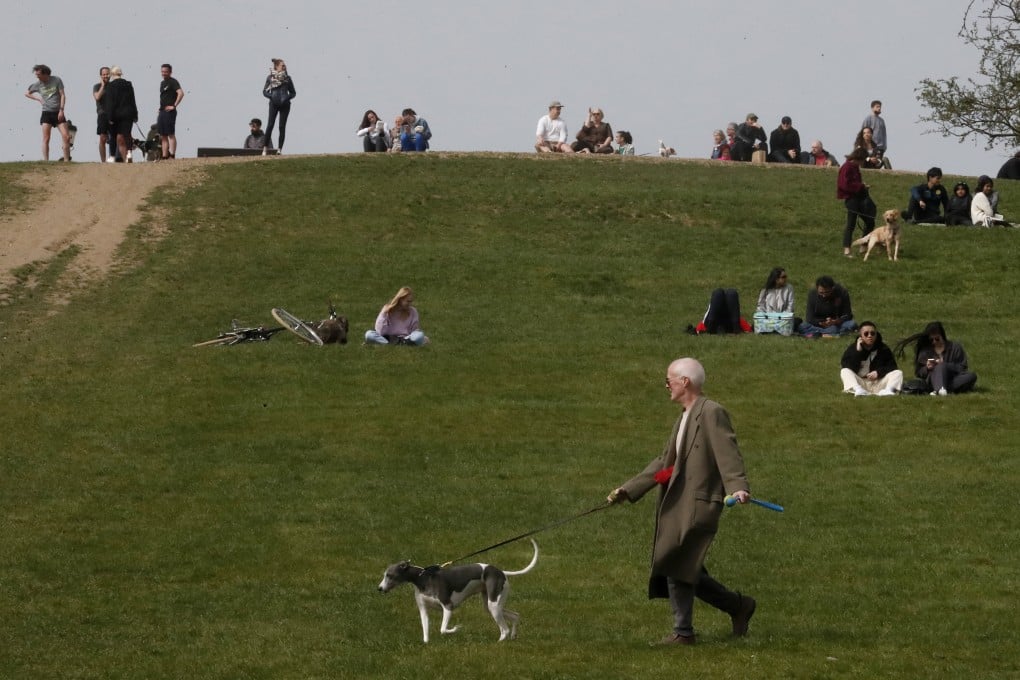 People enjoy the view during sunny weather at Primrose Hill in London on Thursday. Photo: AP