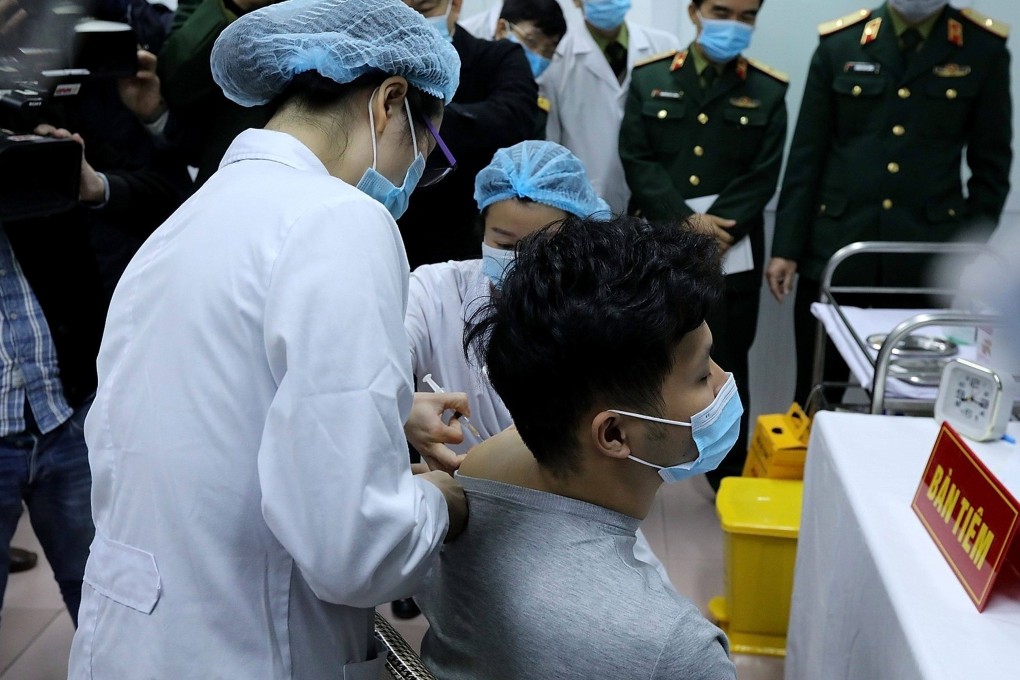 Vietnamese military medical officials give a shot of the Covid-19 vaccine Nanocovax, developed by Vietnamese pharmaceutical firm Nanogen at the Military Medical University in Hanoi. Photo: Vietnam News Agency / AFP