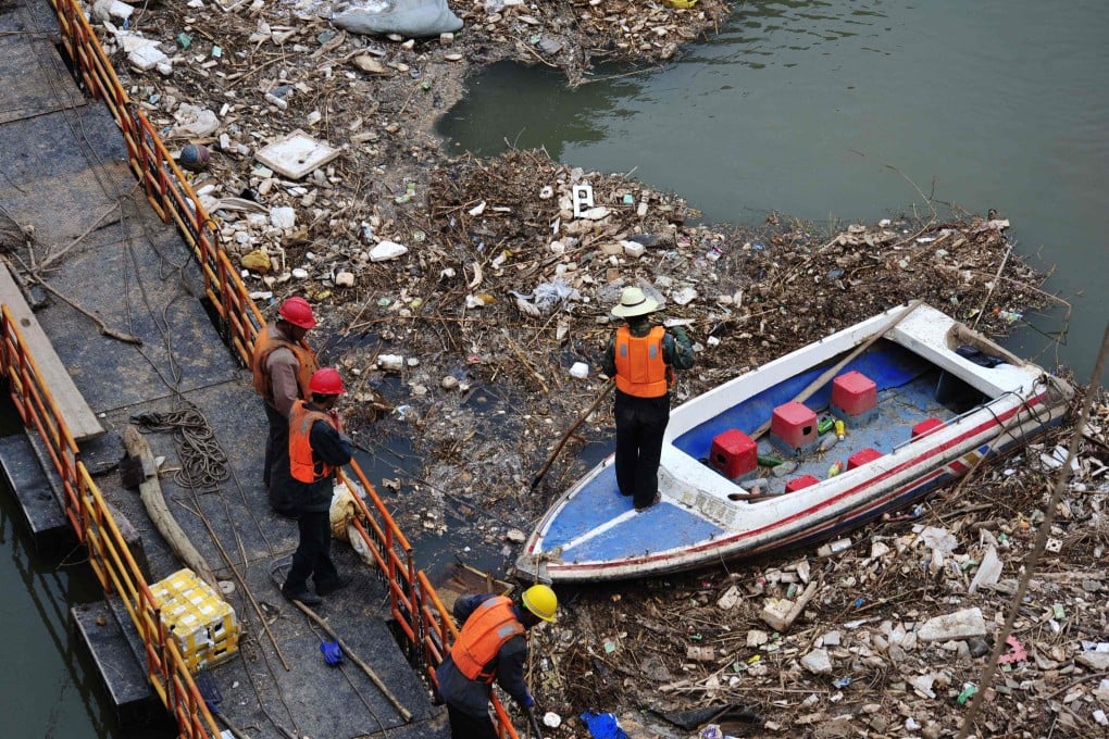 A worker clears rubbish from the Yellow River, where a survey of sewers is to be carried out to identify sources of pollution. Photo: AP