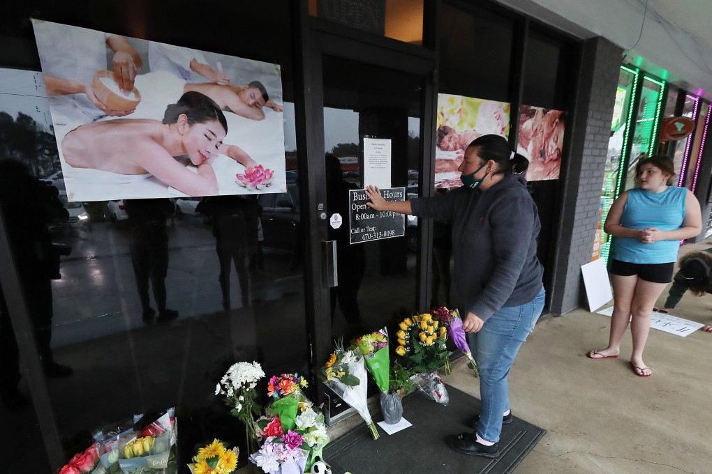 A mourner places her hand on the door in a moment of grief at Young’s Asian Massage in Acworth, Georgia. File photo: Journal-Constitution/TNS