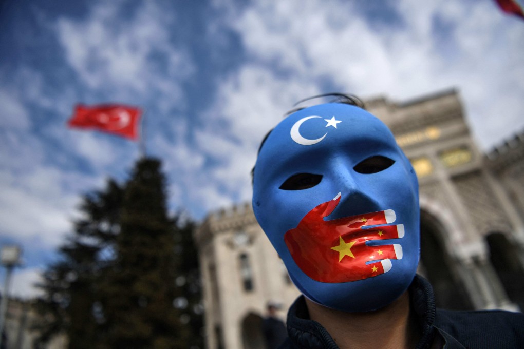 A demonstrator wearing a mask painted with the colours of the flag of East Turkestan takes part in a protest in Istanbul on Thursday. Photo: AFP