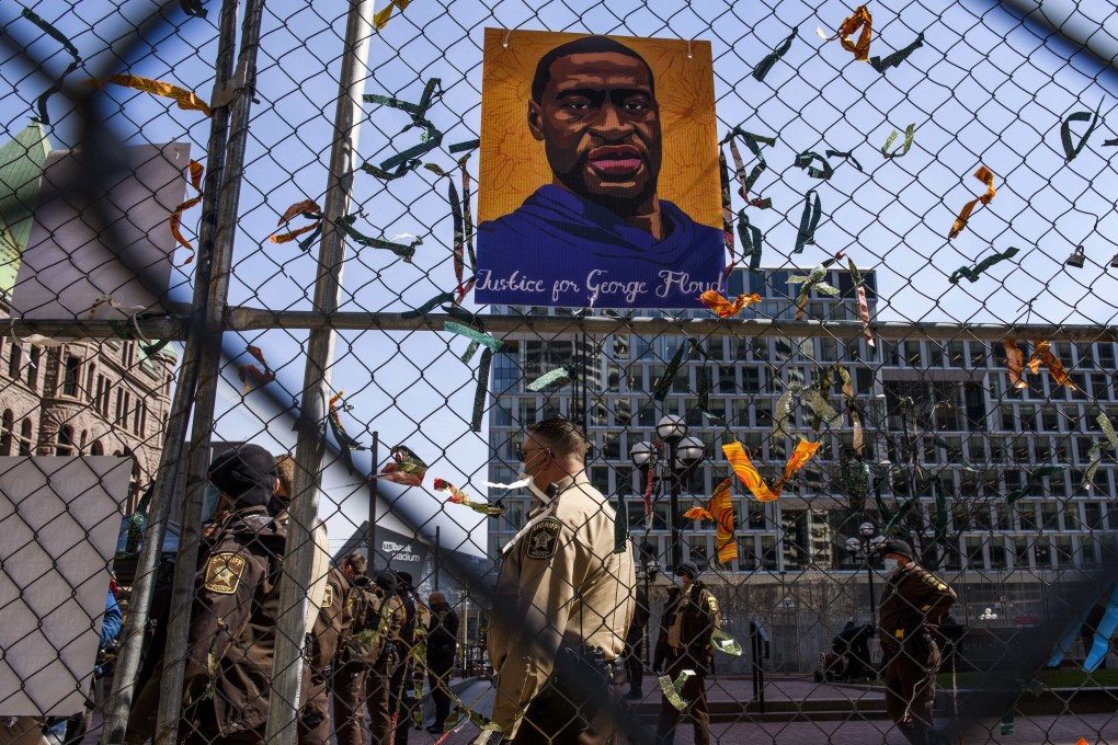 Law enforcement stands guard as crews remove artwork from temporary fencing outside the Hennepin County Government Centre in Minneapolis on Friday, as the trial of Derek Chauvin for the murder of George Floyd continues. Photo: AFP