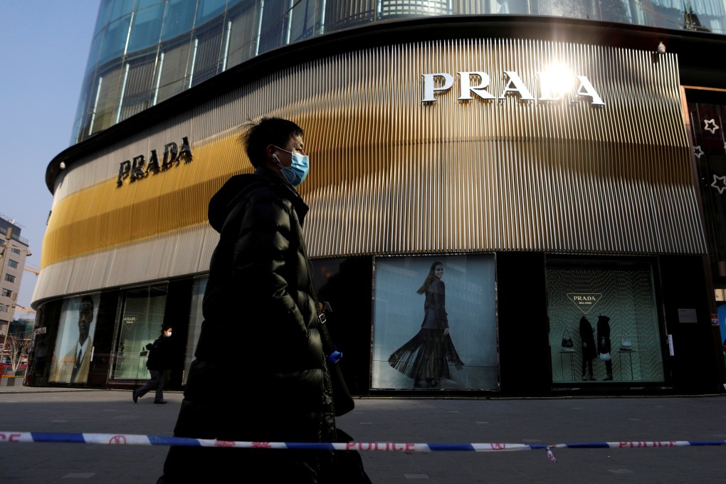 A man walks past a store for luxury brand Prada in Beijing. Wellington Management is expanding its staff in Asia as it bets on increaing wealth in China and other parts of the region. Photo: Reuters