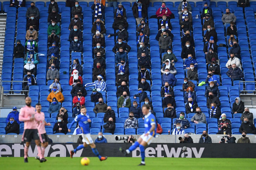 Football fans wearing face masks sit socially distanced during the English Premier League match between Brighton and Hove Albion and Sheffield United at the American Express Community Stadium in Brighton, UK. Photo: AFP