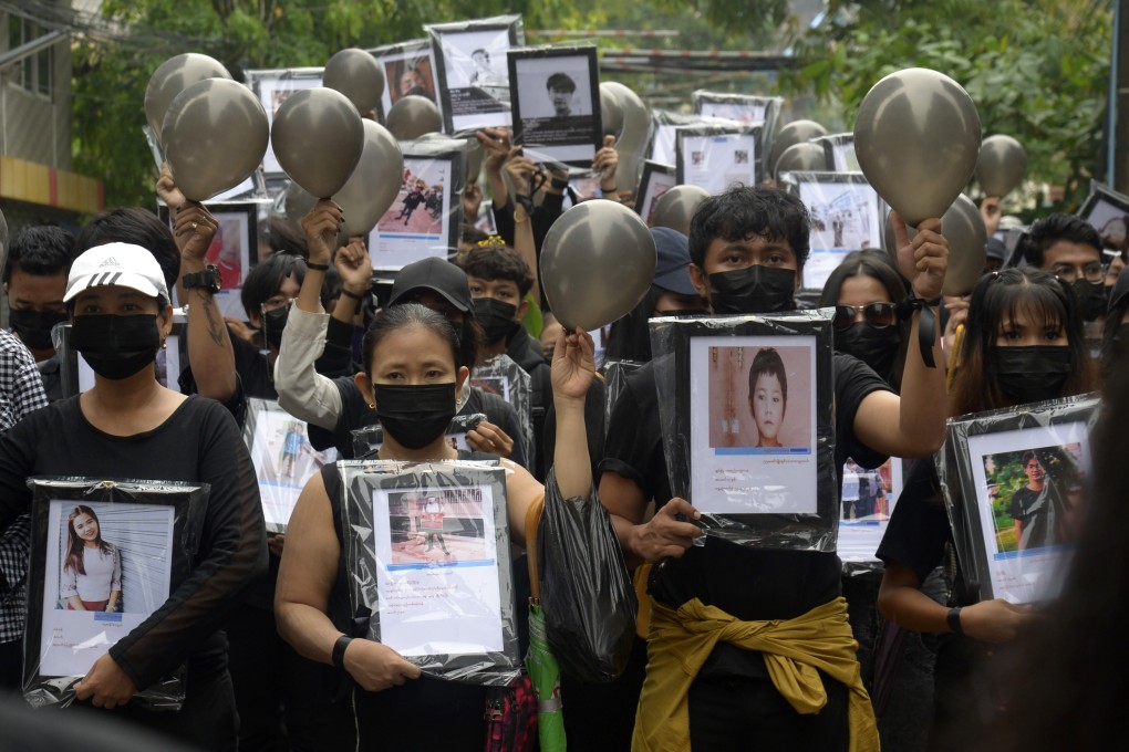 Anti-coup protesters in Myanmar hold pictures of those killed by security forces. Photo: AP