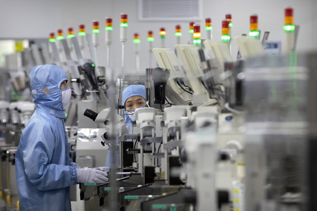 Employees wearing protective equipment work at a semiconductor production facility for Renesas Electronics during a government-organised tour for journalists in Beijing, China on May 14, 2020. Photo: AP Photo