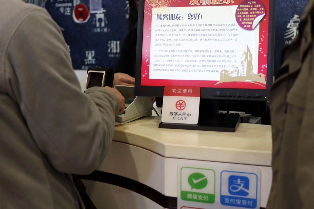 A sign for China’s digital yuan, or e-CNY, is seen above Wechat Pay and Alipay signs at a counter during a trial of the Digital Currency Electronic Payment system at a shopping centre in Beijing on February 10. Photo: Reuters